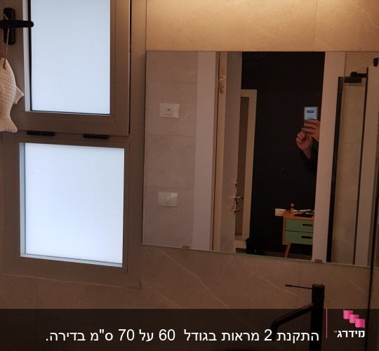 מראה מלבנית עם מסגרת דקה בחדר אמבטיה